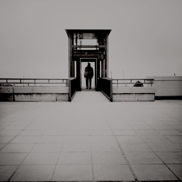 Fahrstuhl zur Hölle? Schwarz-weiß Foto eines nach unten führenden Fahrstuhls