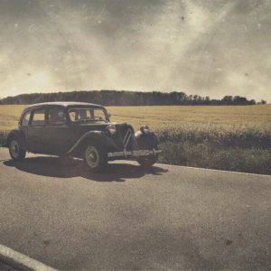 Hipstamatic Foto eines Oldtimers vor einem Rapsfeld